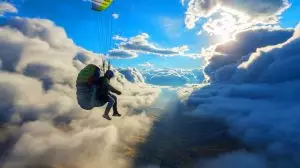 Illustration von einem Paraglider, der in schwindelerregende Höhen gezogen wird. Bild durch KI generiert.